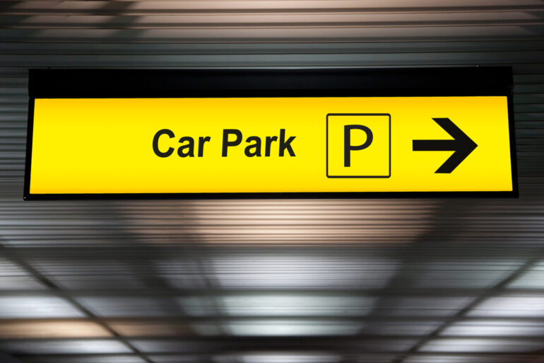 31995298 yellow car park sign with arrow pointing to car parking zone at airport terminal