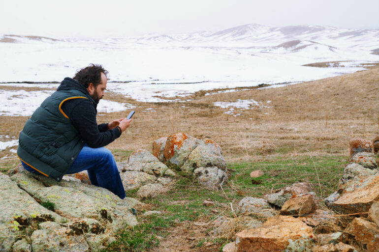 27687186 man in snow landscape using gps on his smartphone