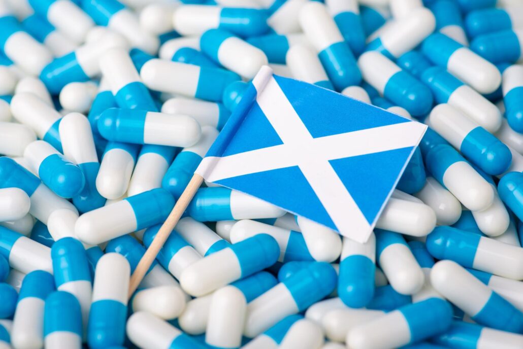 Scottish m edical system. Flag of Scotland between white and blue pills capsules