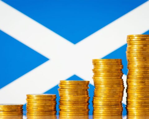 57629656 five stacks of gold coins against flag of scotland forming rising chart