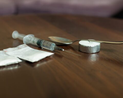 79021986 drug spoon and syringe on a table