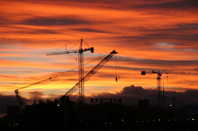 87995268 sunset and construction cranes over glasgow skyline