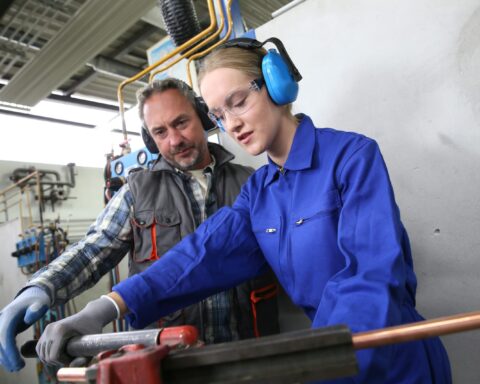 74117298 young woman in professional training to become plumber