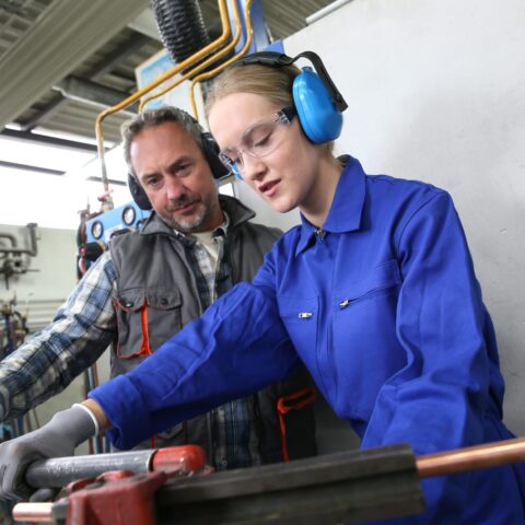 74117298 young woman in professional training to become plumber