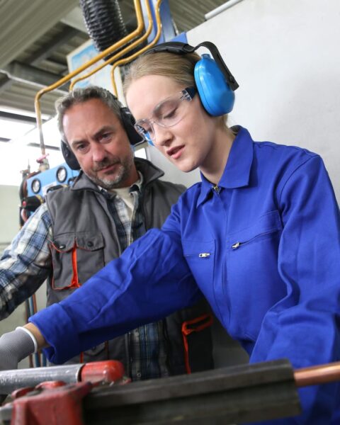 74117298 young woman in professional training to become plumber