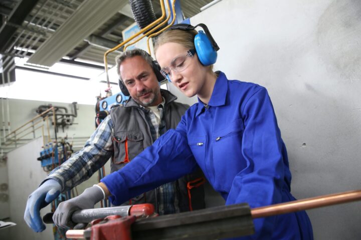 74117298 young woman in professional training to become plumber