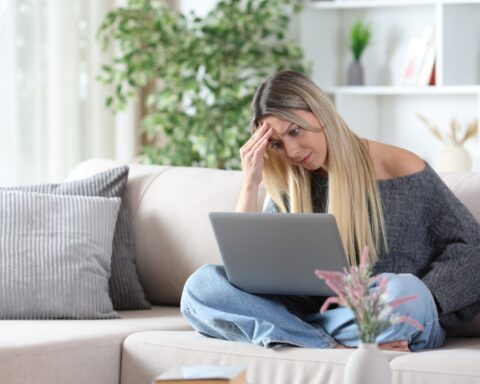 101064324 worried woman on a sofa checking personal computer