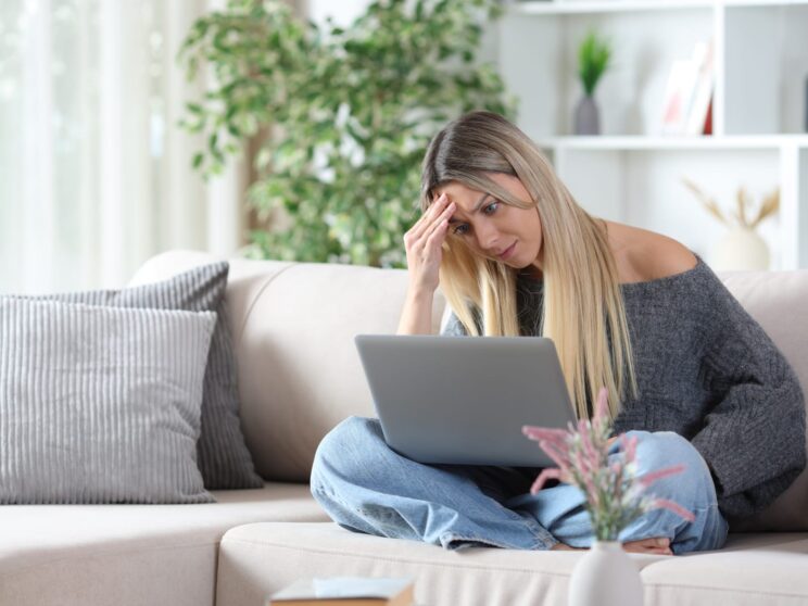 101064324 worried woman on a sofa checking personal computer