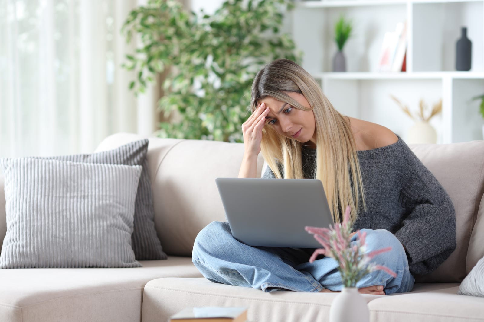 101064324 worried woman on a sofa checking personal computer