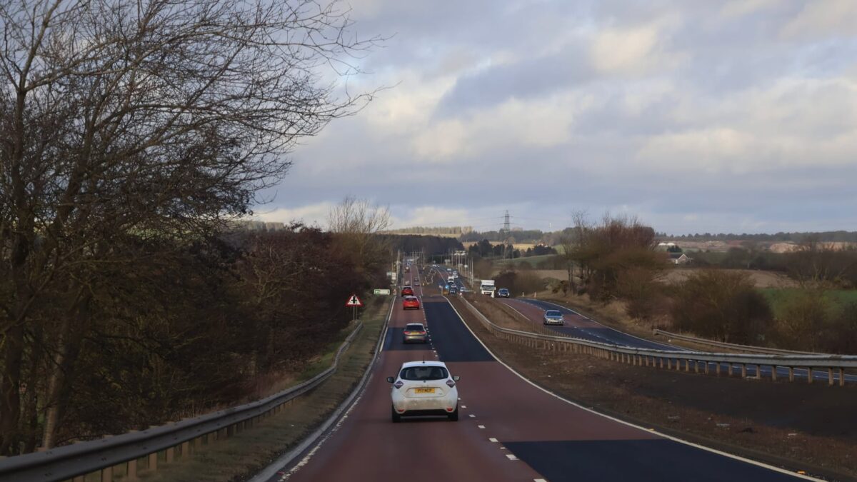 101636200 scotland 12 january 2026 busy rural highway with cars and guardrails under overcast sky