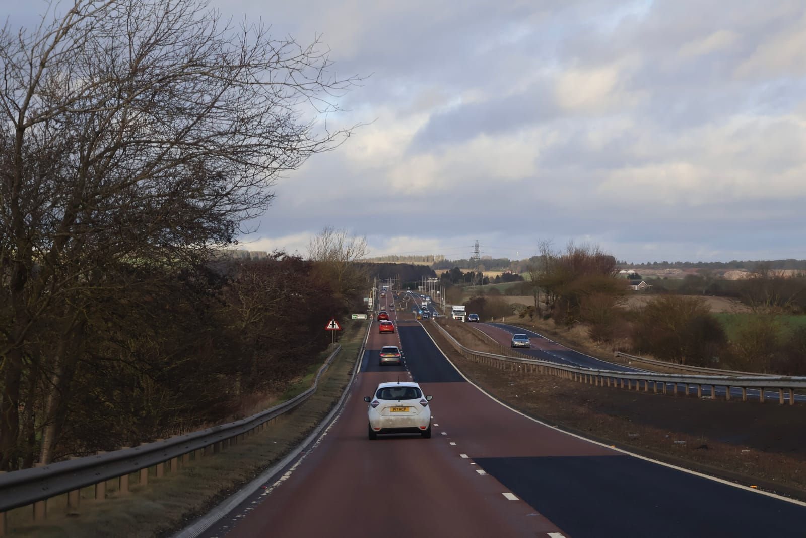 101636200 scotland 12 january 2026 busy rural highway with cars and guardrails under overcast sky