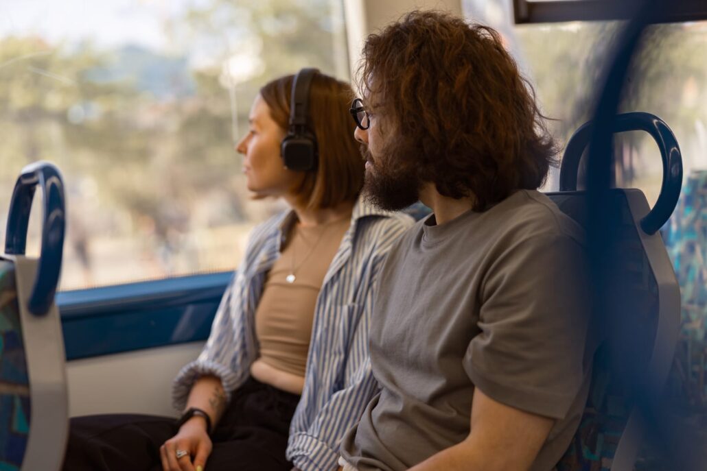 56621078 handsome tourist couple is travel together while riding in public bus and looking at window