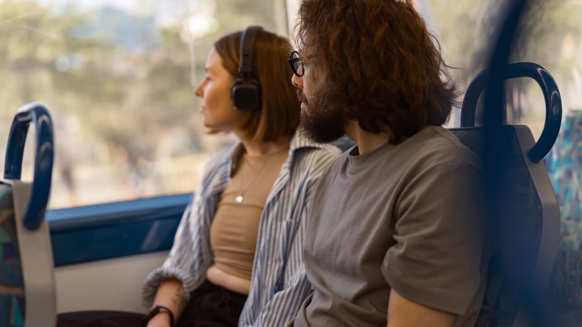 56621078 handsome tourist couple is travel together while riding in public bus and looking at window