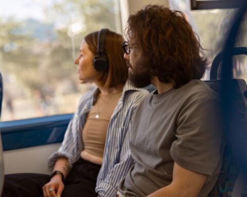 56621078 handsome tourist couple is travel together while riding in public bus and looking at window