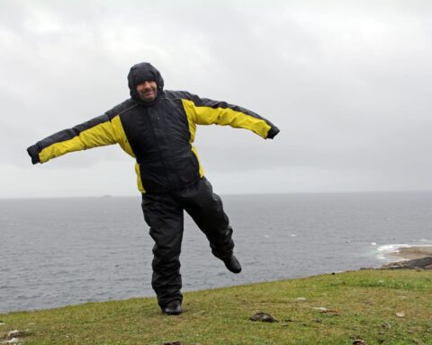 72577298 a man in the rain and storm a very windy day by the sea