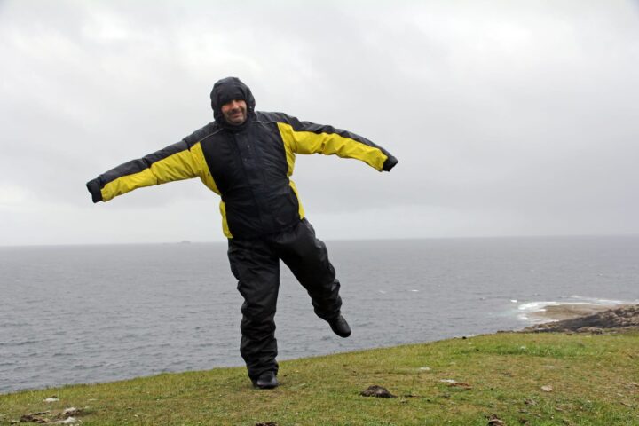 72577298 a man in the rain and storm a very windy day by the sea