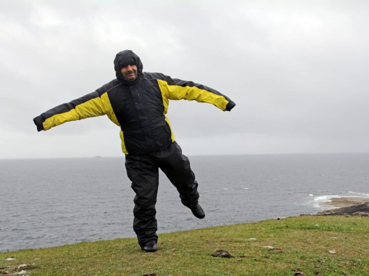 72577298 a man in the rain and storm a very windy day by the sea