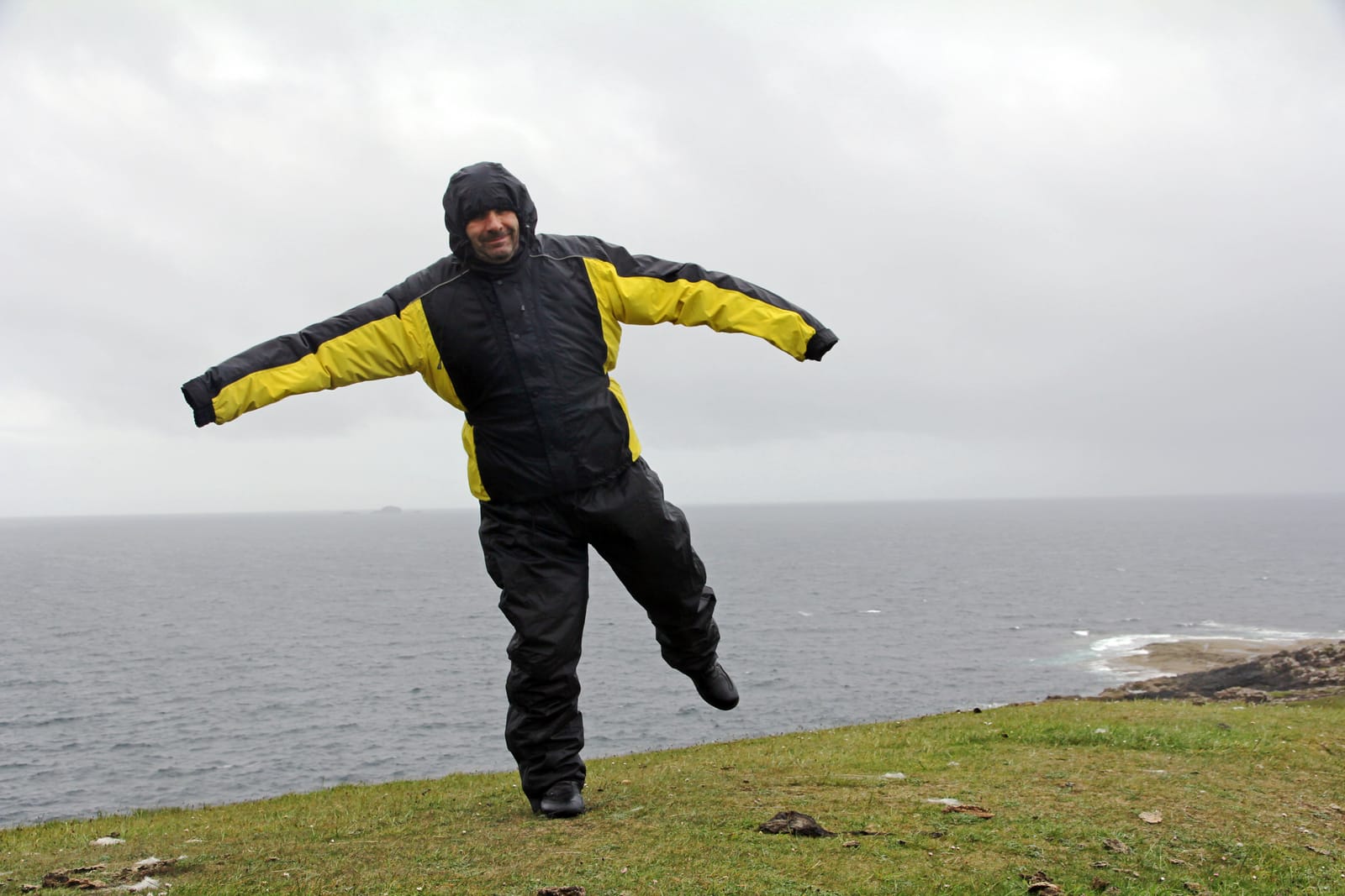 72577298 a man in the rain and storm a very windy day by the sea