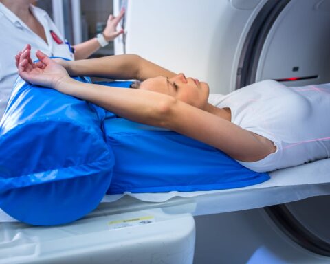 77725612 pretty young woman goiing through a computerized axial tomography cat scan medical testexamination in a modern hospital color toned image shallow dof