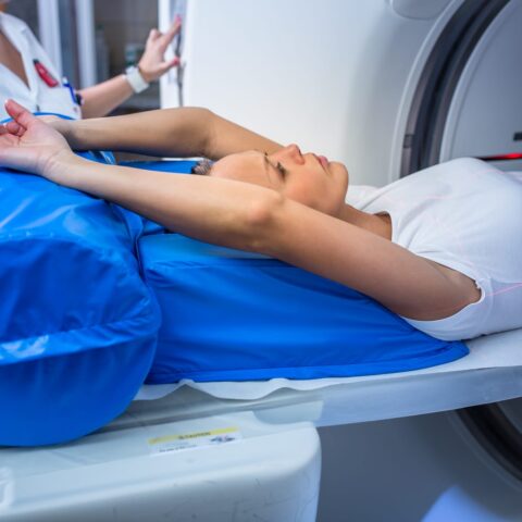 77725612 pretty young woman goiing through a computerized axial tomography cat scan medical testexamination in a modern hospital color toned image shallow dof