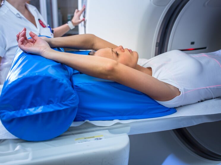 77725612 pretty young woman goiing through a computerized axial tomography cat scan medical testexamination in a modern hospital color toned image shallow dof